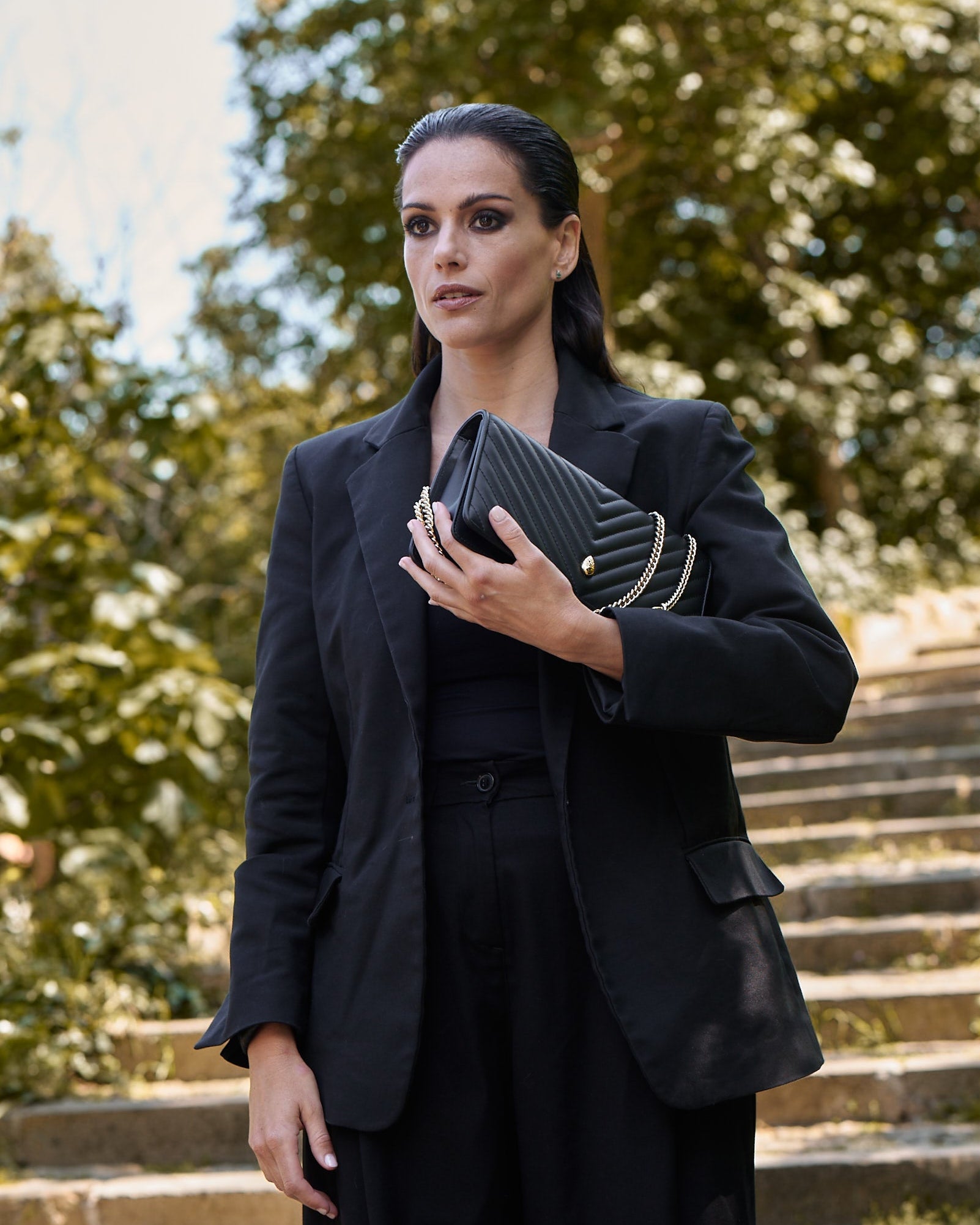 Black leather handbag worn by woman chic style – Menière Paris