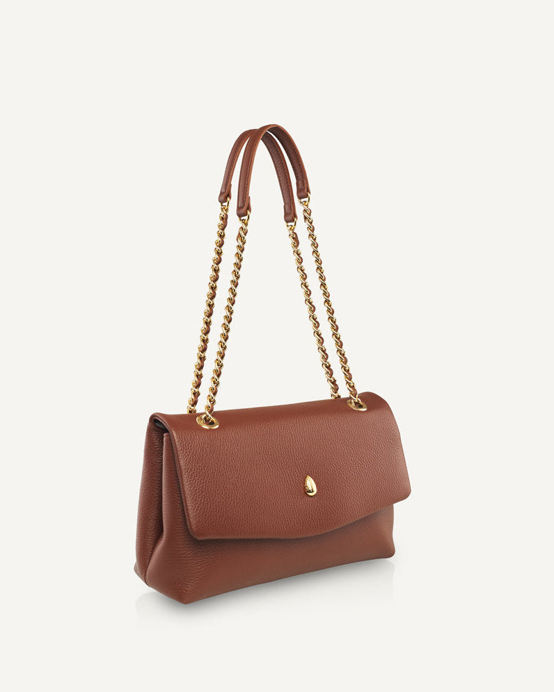 Close-up of brown leather bag with gold chain detail