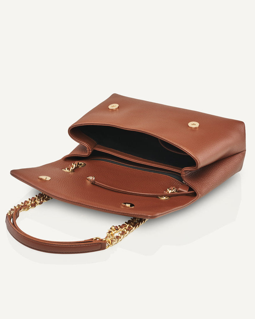 Open brown leather bag showing interior compartments and storage