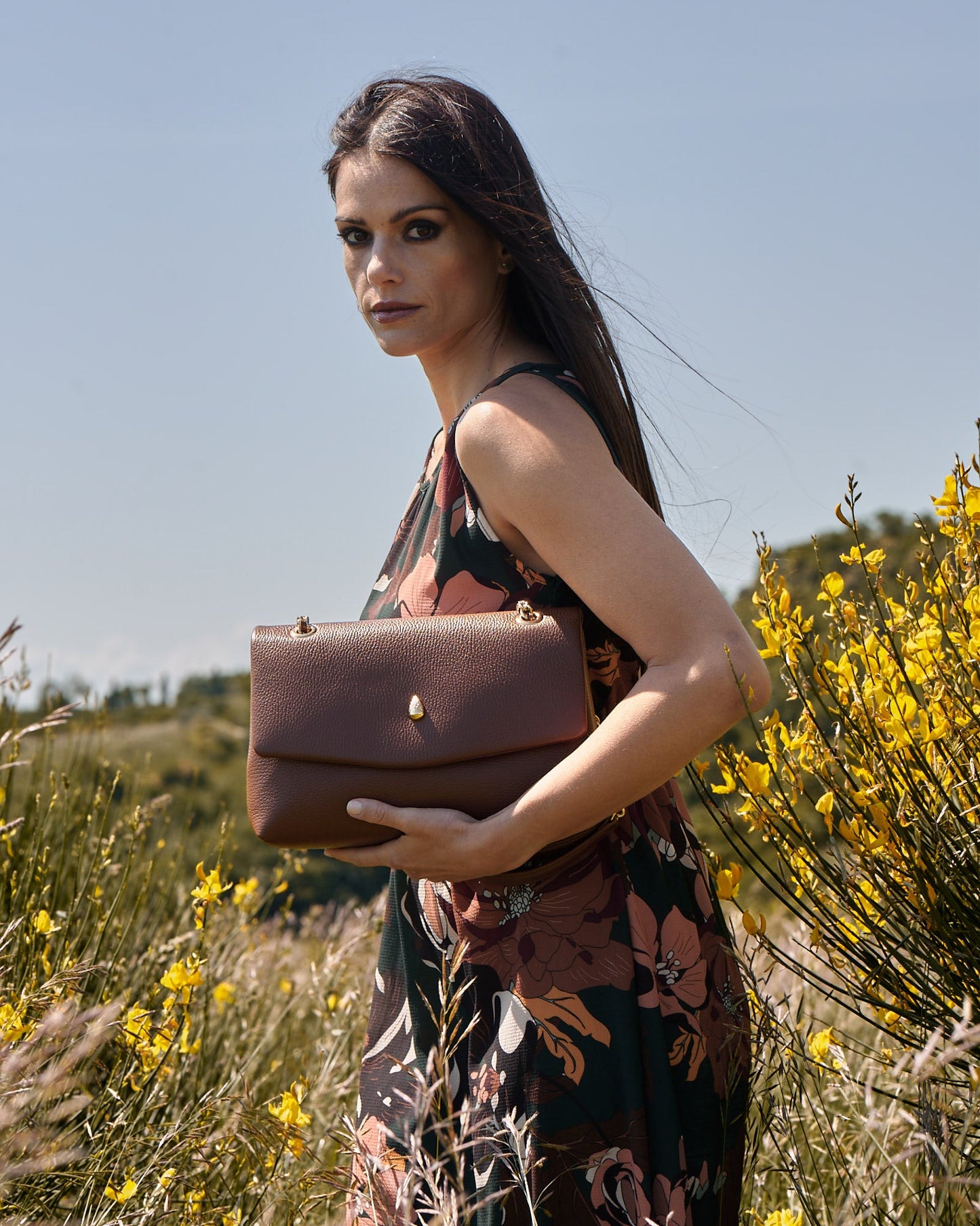 Woman holding a brown leather bag showing design and size